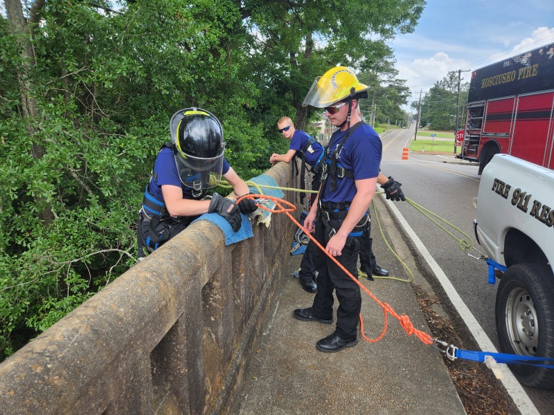 Chris Mosely preparing to rappel as Lieutenant Curtis Pope stands by to provide assistance